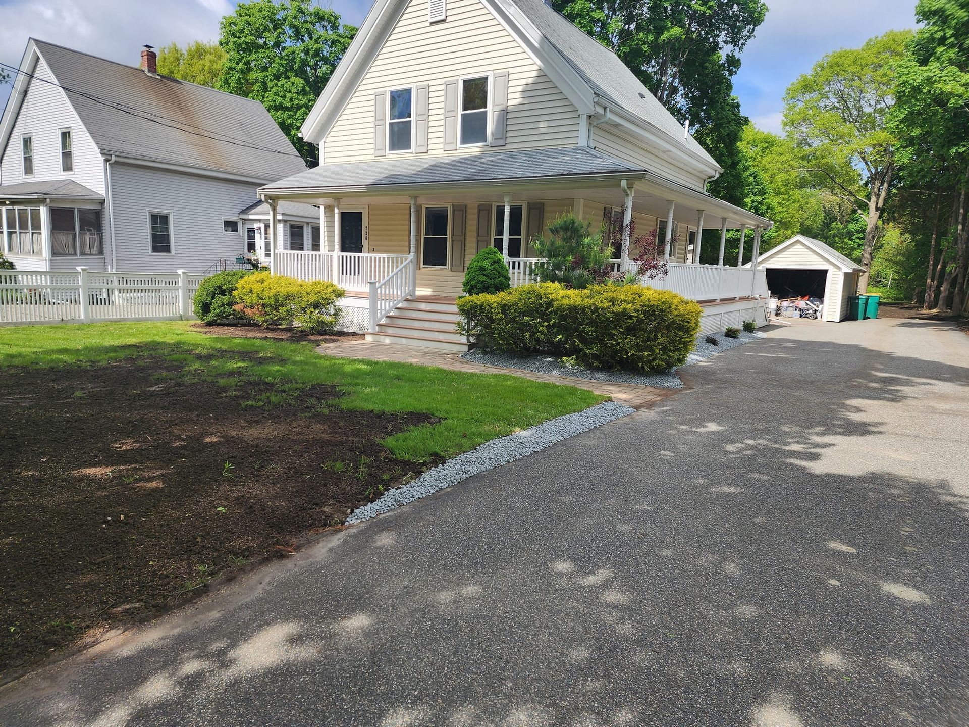 A white house with a large porch and a garage