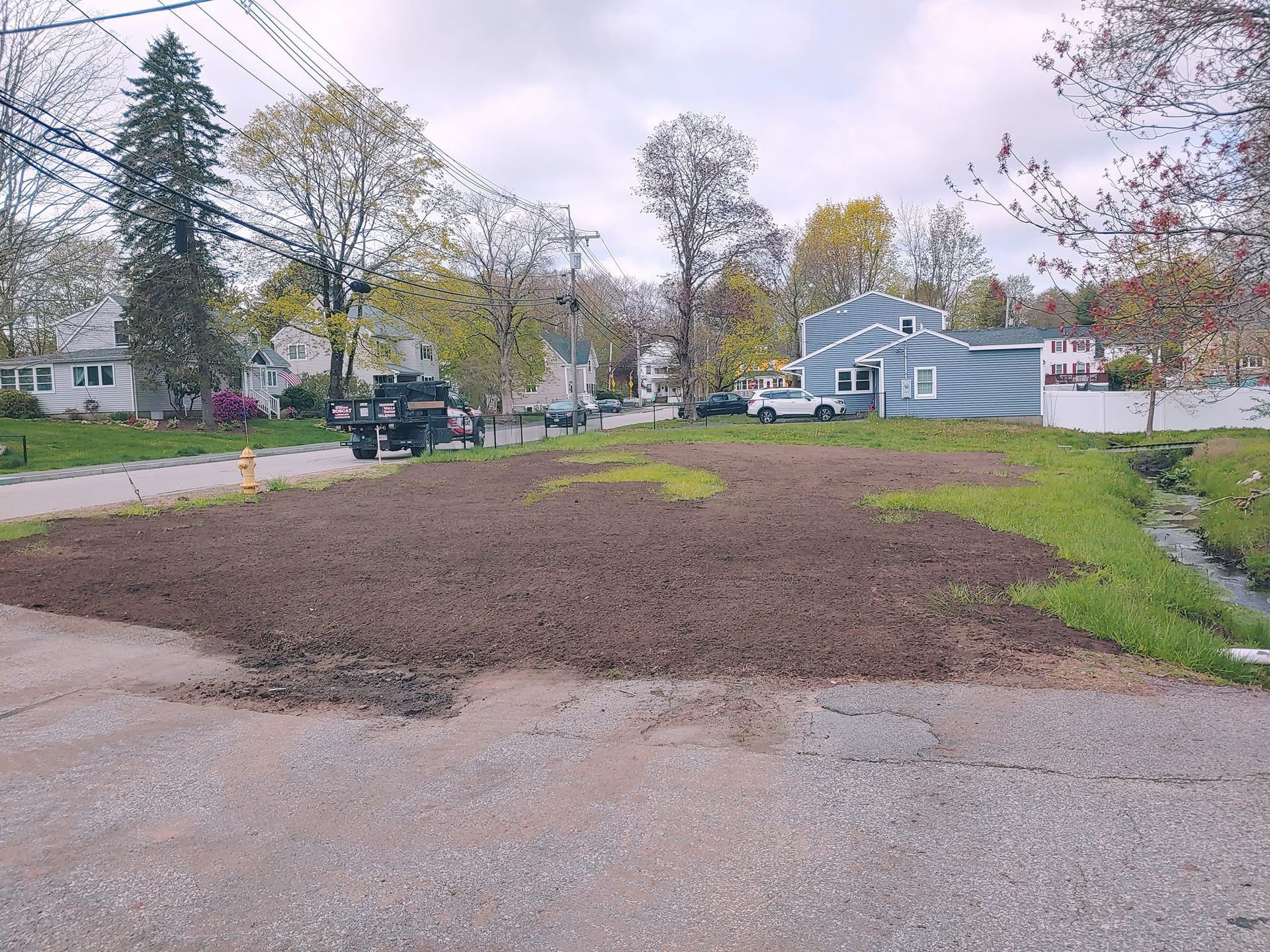 A dirt road with a few houses in the background