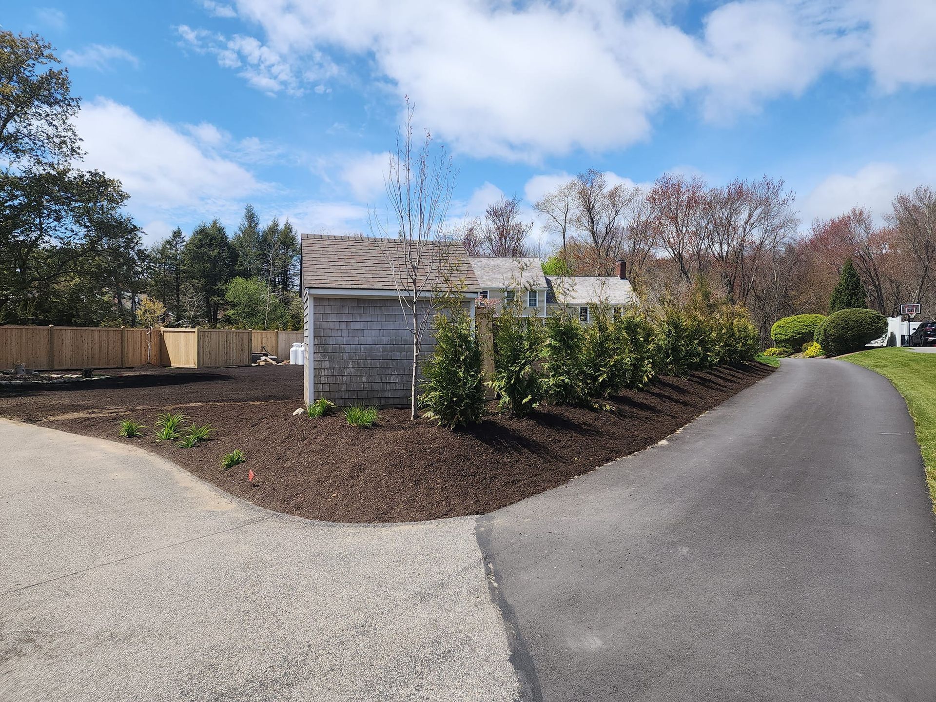 A gravel driveway leading to a house on a sunny day