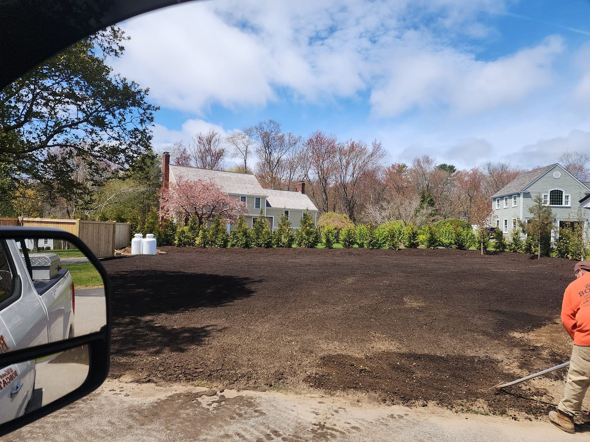 A man is standing in the dirt in front of a house