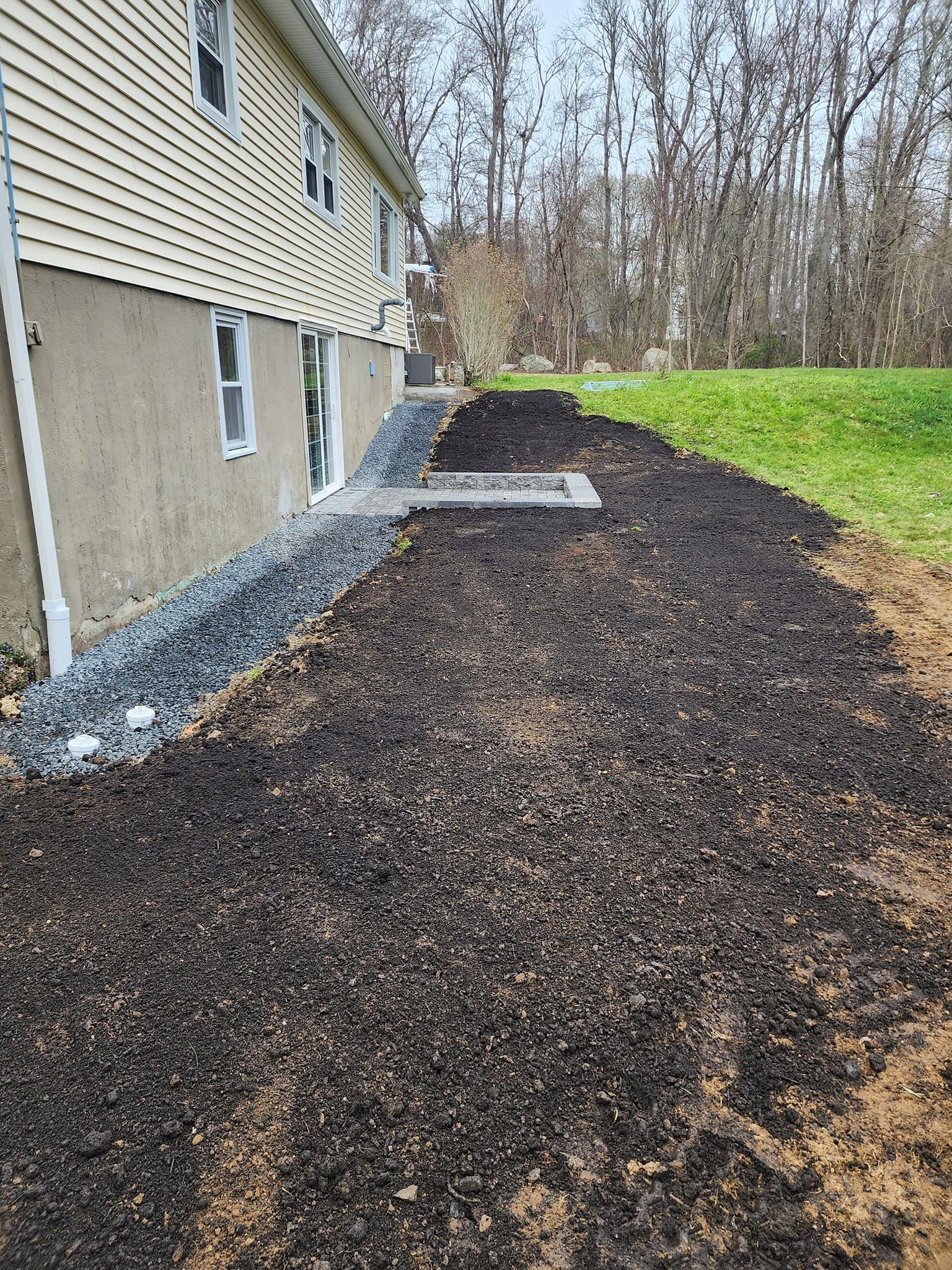 A house with a large pile of dirt in front of it.