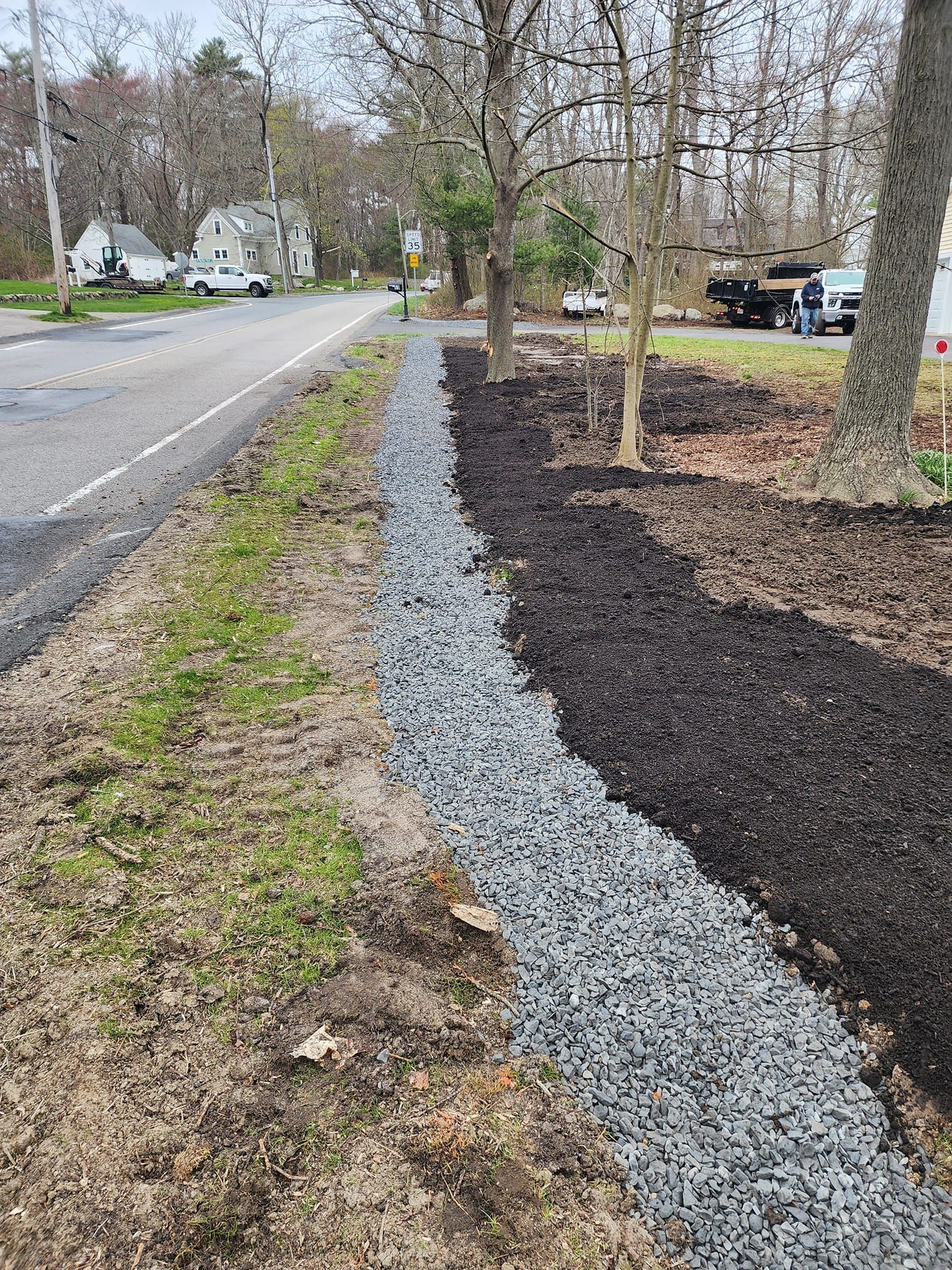 A gravel fence is being built next to a road.