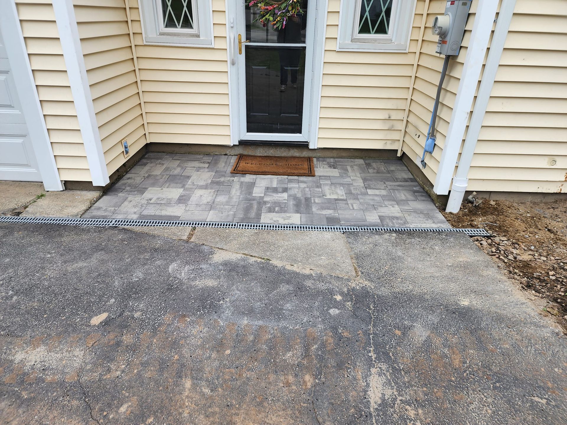 The front door of a house with a brick walkway leading to it.
