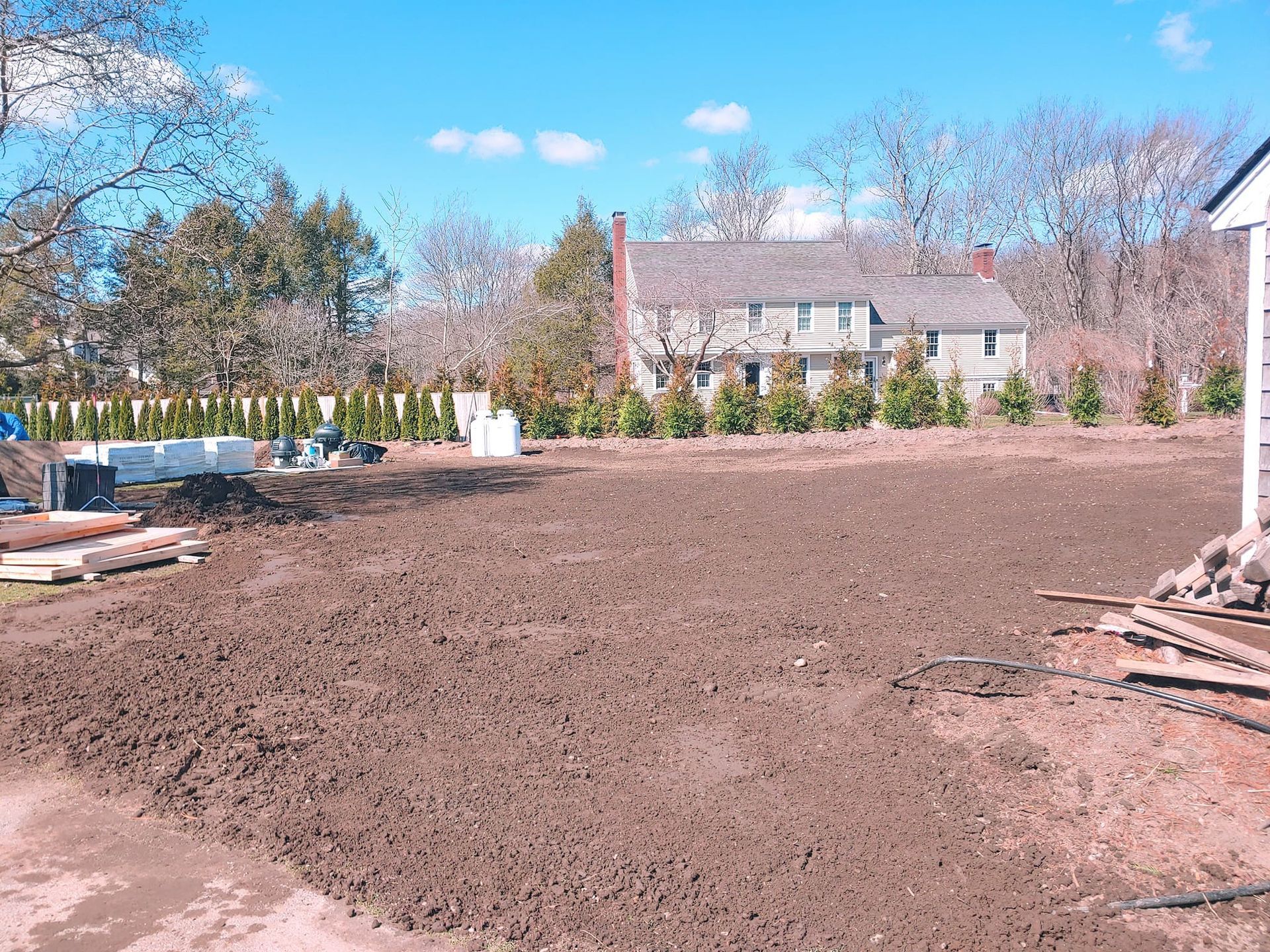 A large dirt field with a house in the background