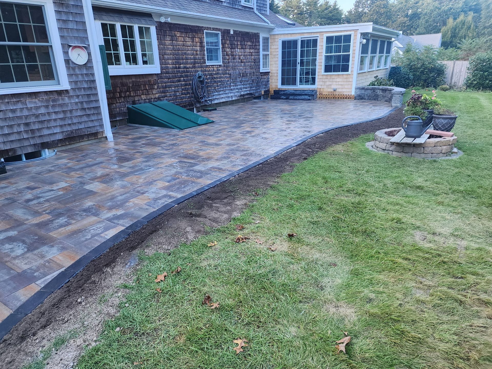 A patio is being built in the backyard of a house.