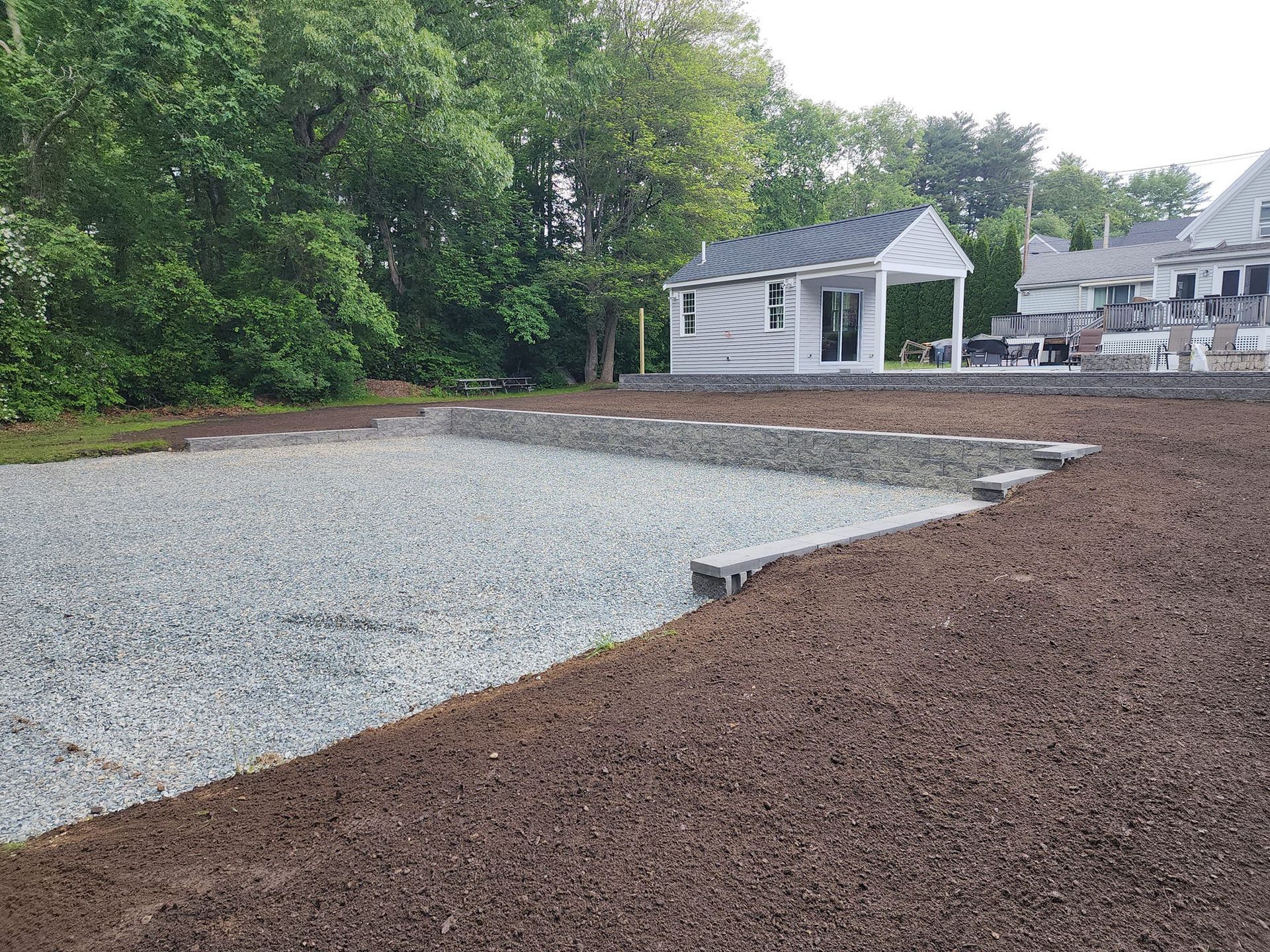 A gravel driveway leading to a house with a gazebo in the background.