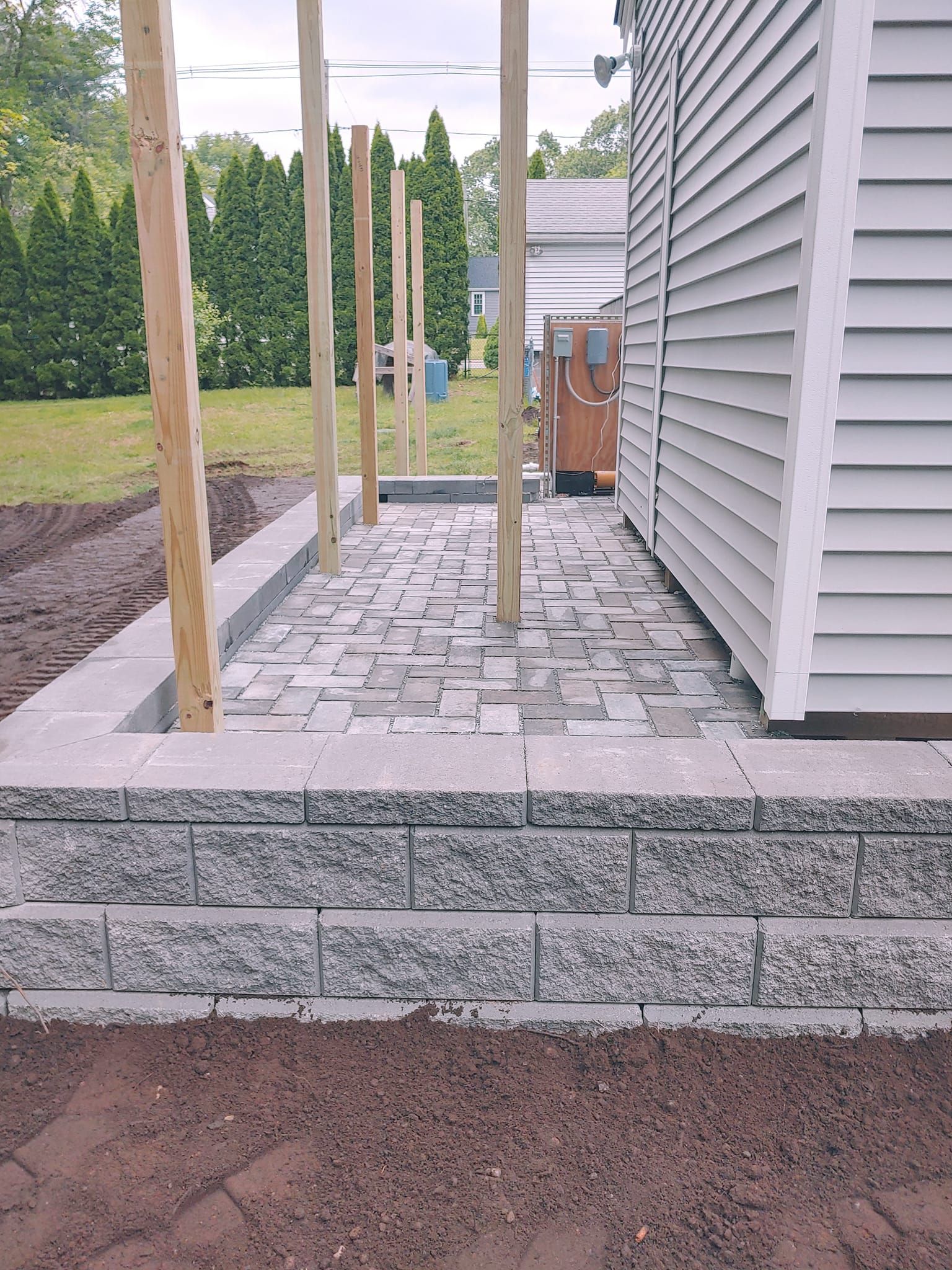 A brick walkway is being built in front of a house.