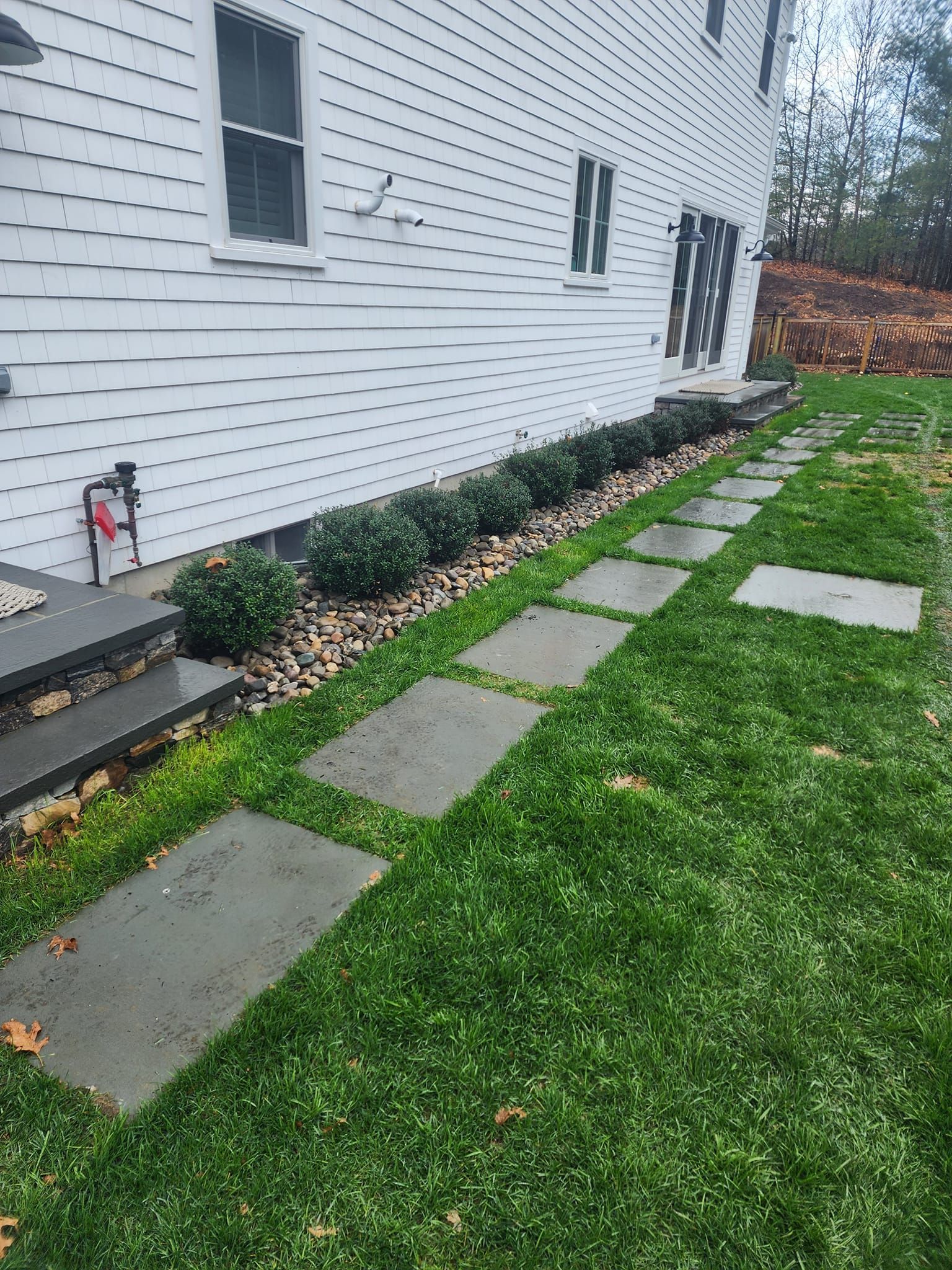 A stone walkway leading to the side of a house.