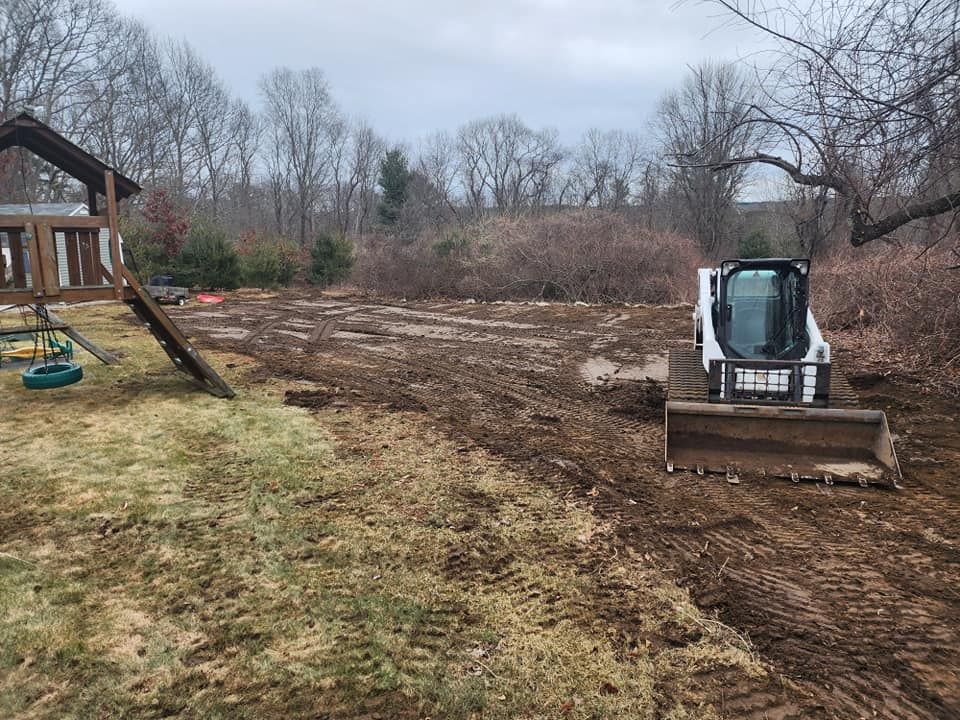 A bulldozer is sitting in the middle of a dirt field.