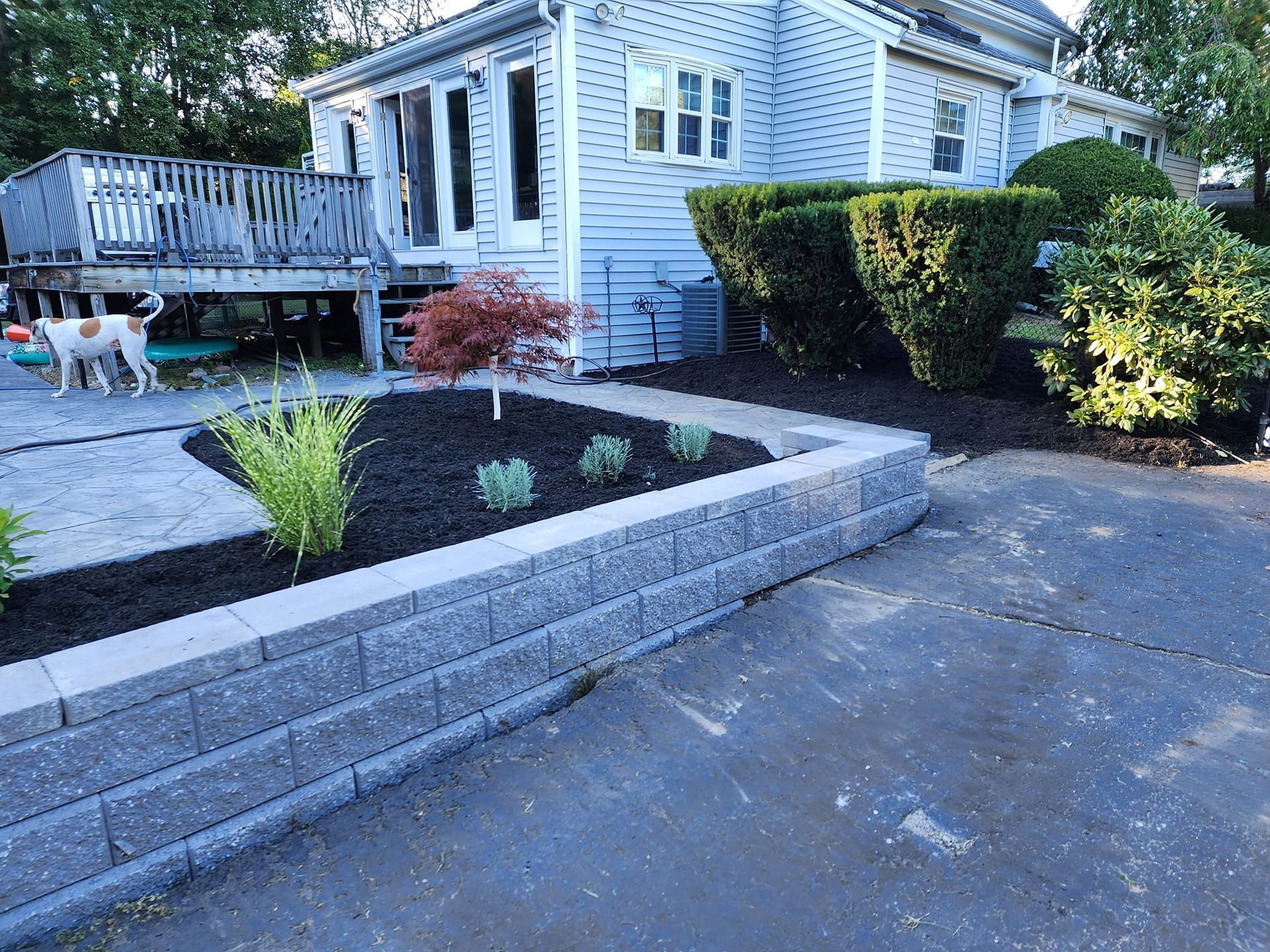 A white house with a brick wall in front of it