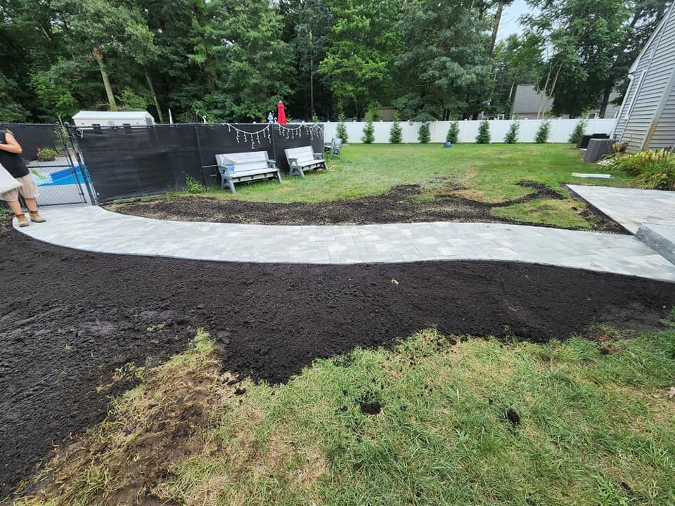 A walkway is being built in the backyard of a house.