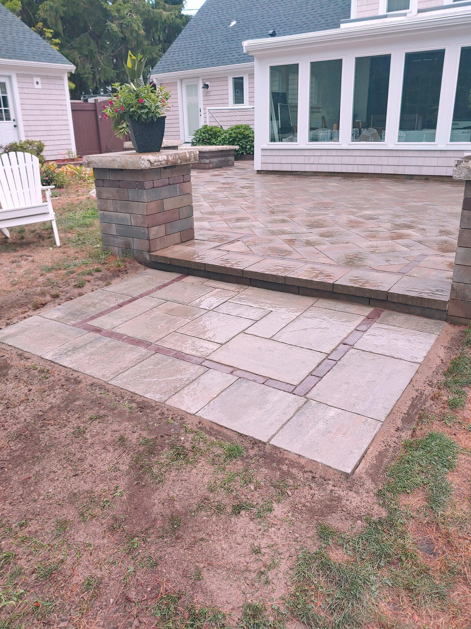 A patio is being built in the backyard of a house.