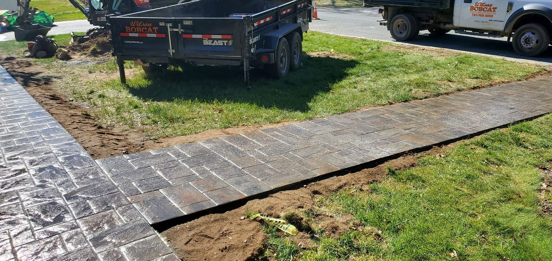 A truck is parked on the side of the road next to a sidewalk.