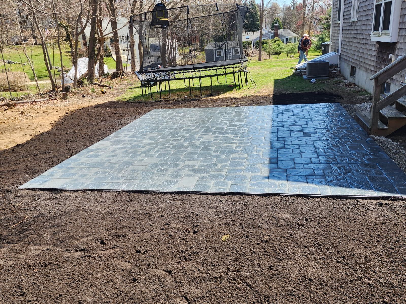 A patio is being built in the backyard of a house.