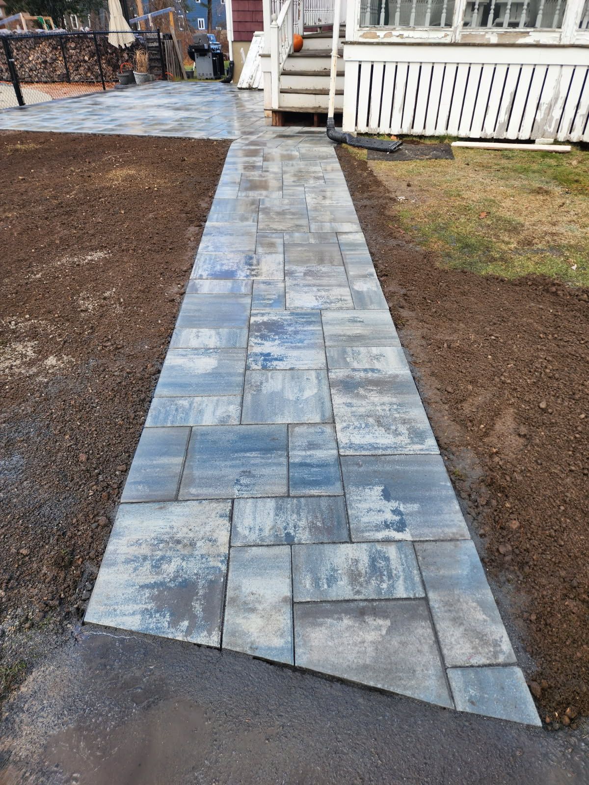 A stone walkway leading to a house with stairs.