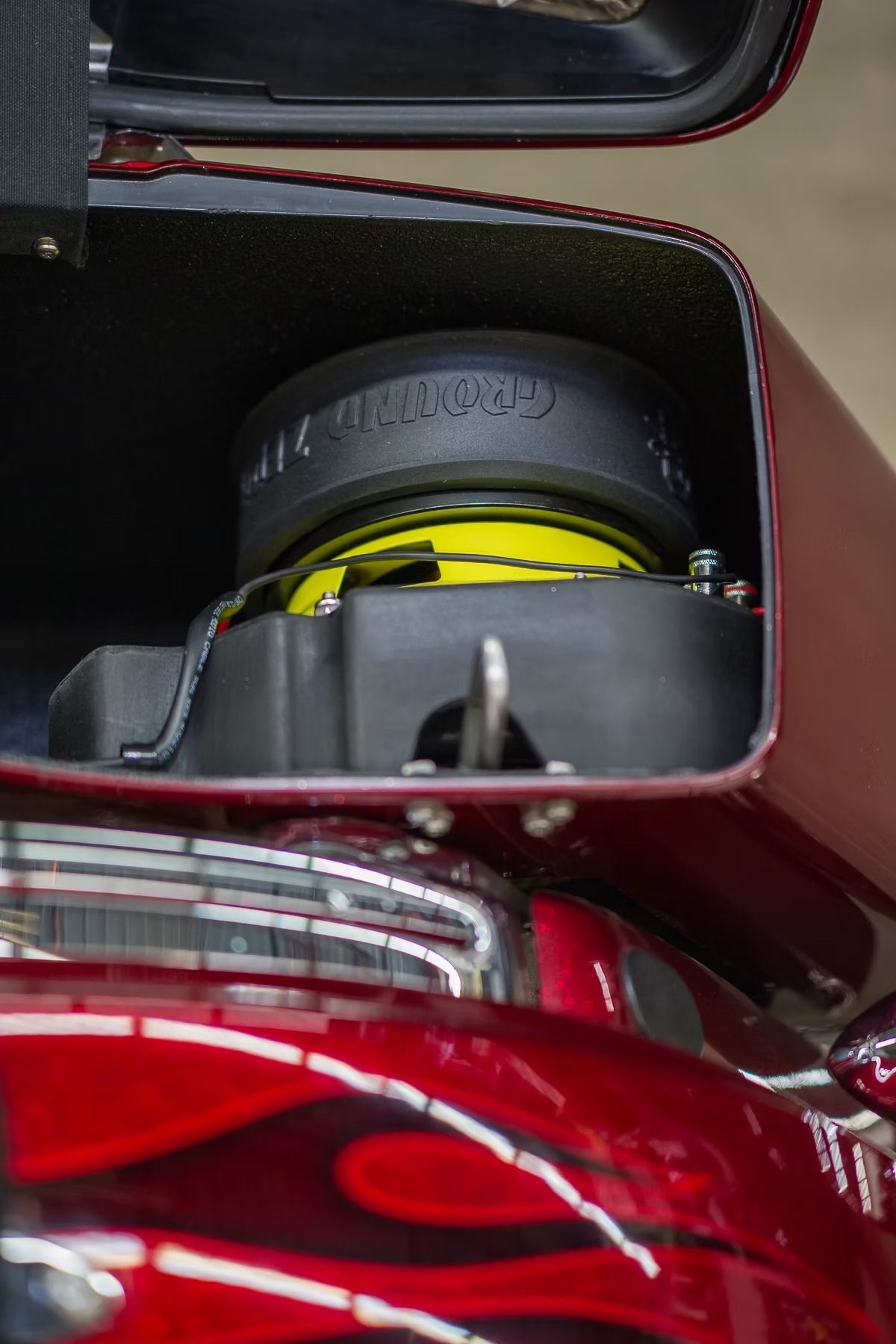 Close-up of a red car’s rear compartment with a black and yellow mechanical part inside
