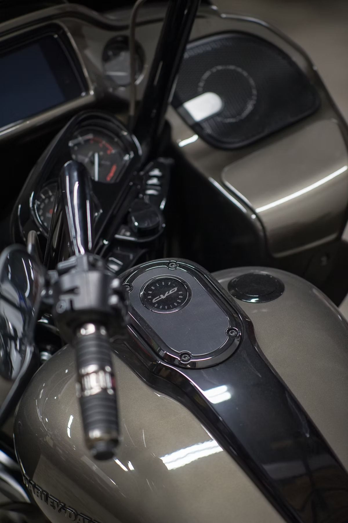 Close-up of a black and gray motorcycle fuel tank and handlebars.