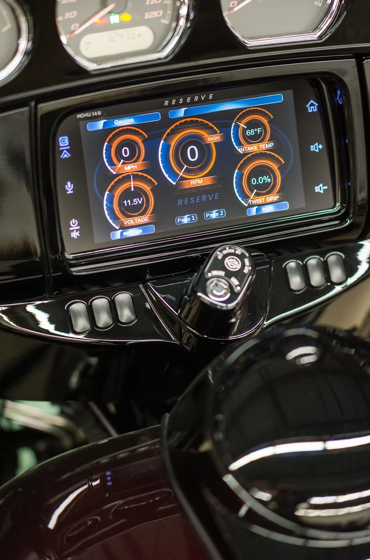 Car dashboard with a central touchscreen showing orange gauge-style controls and a glossy black gear selector.