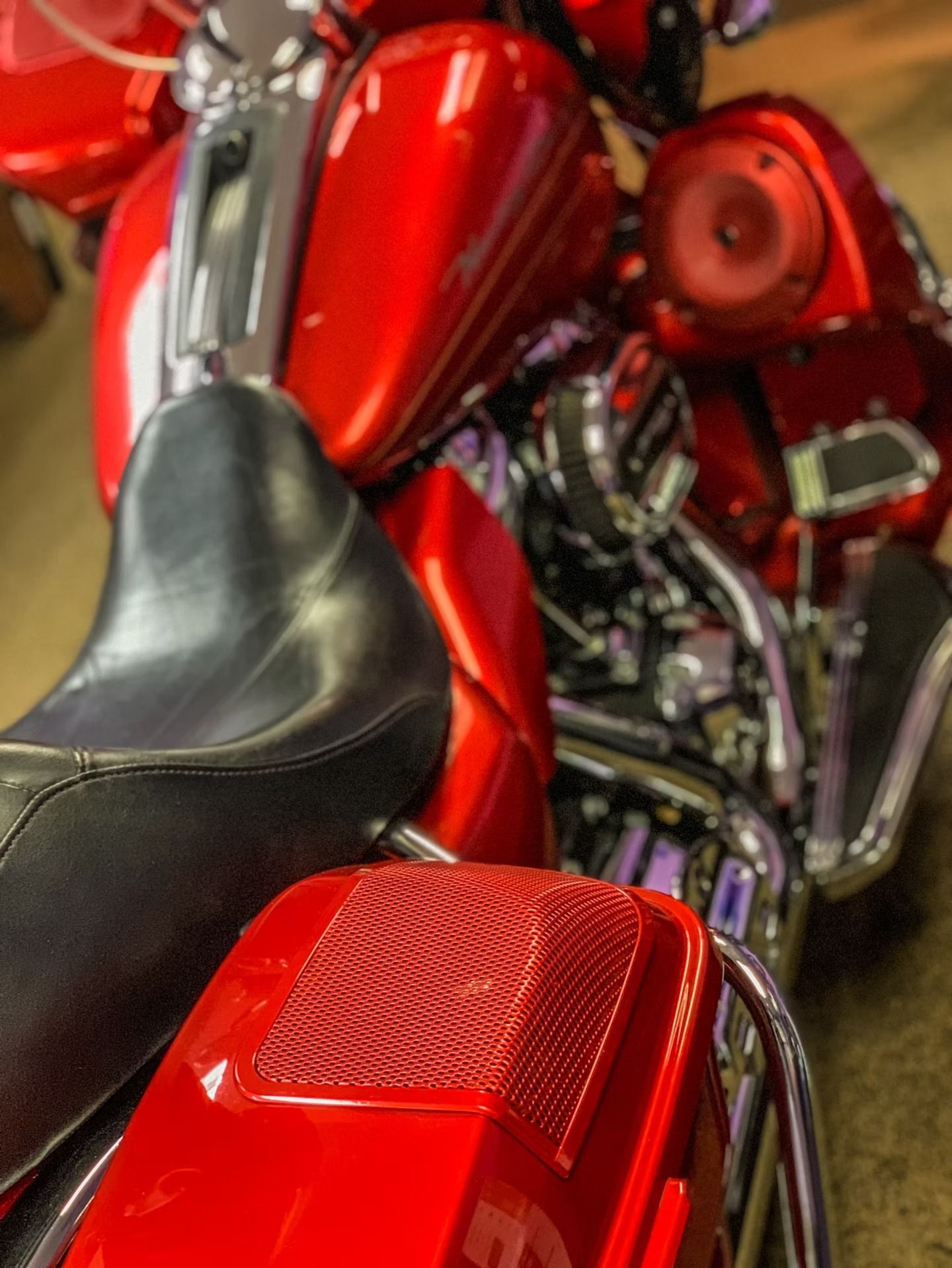 Close-up of a red motorcycle seat, chrome engine, and red fuel tank details