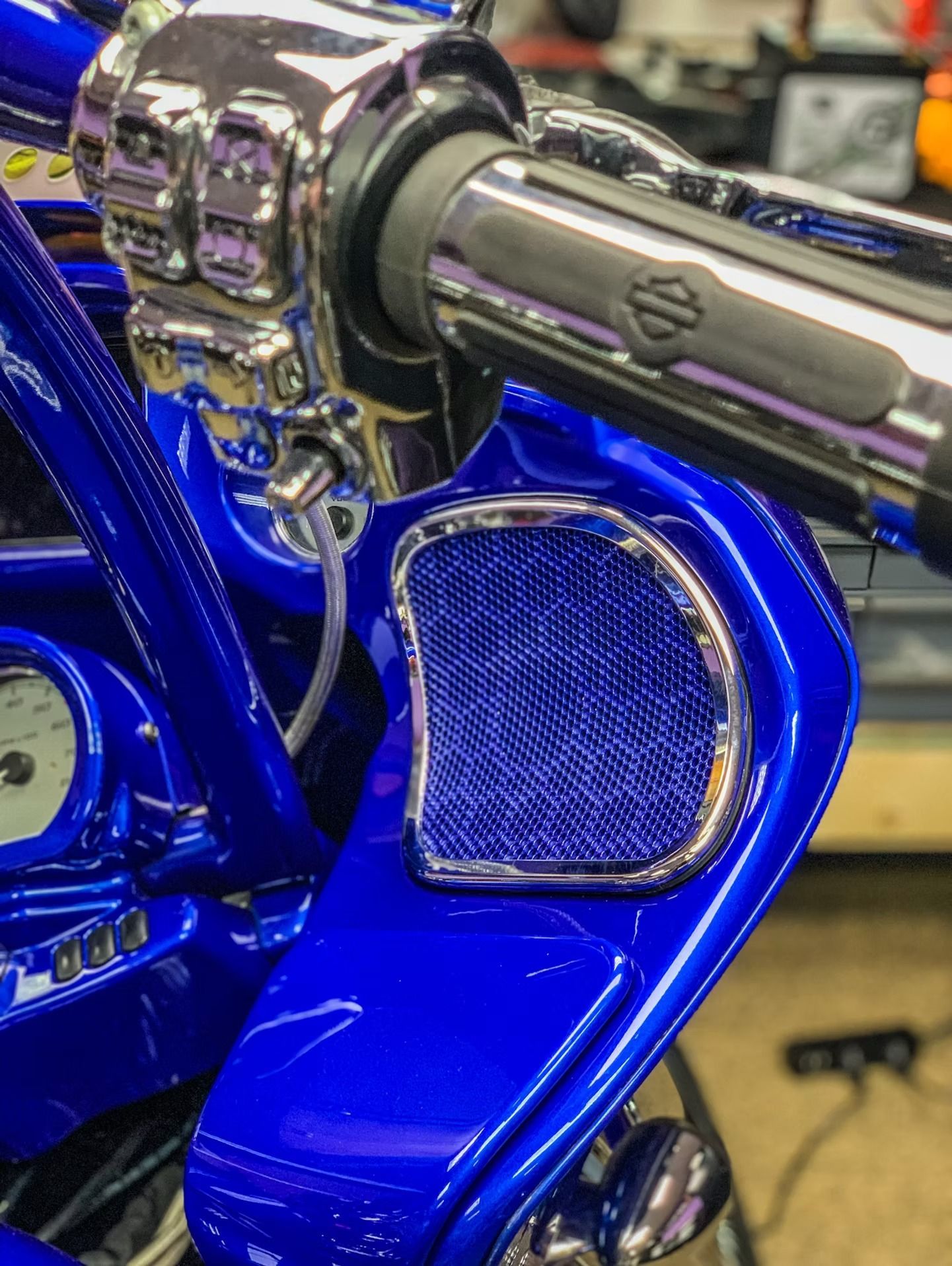 Blue custom motorcycle with chrome engine and exhaust close-up