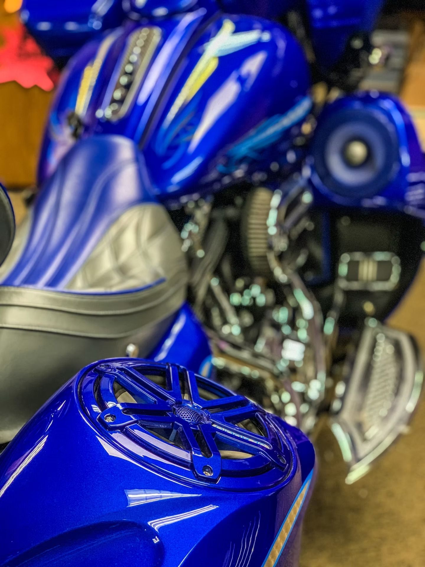 Close-up of a glossy blue motorcycle with chrome engine details and a black seat