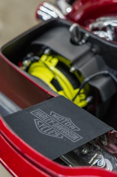 Open motorcycle storage compartment with yellow and black gear inside