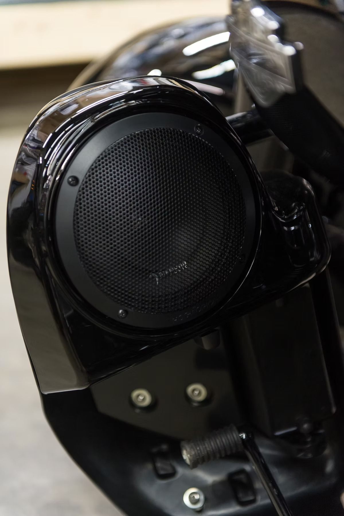 Close-up of a black motorcycle rearview mirror and handlebar assembly