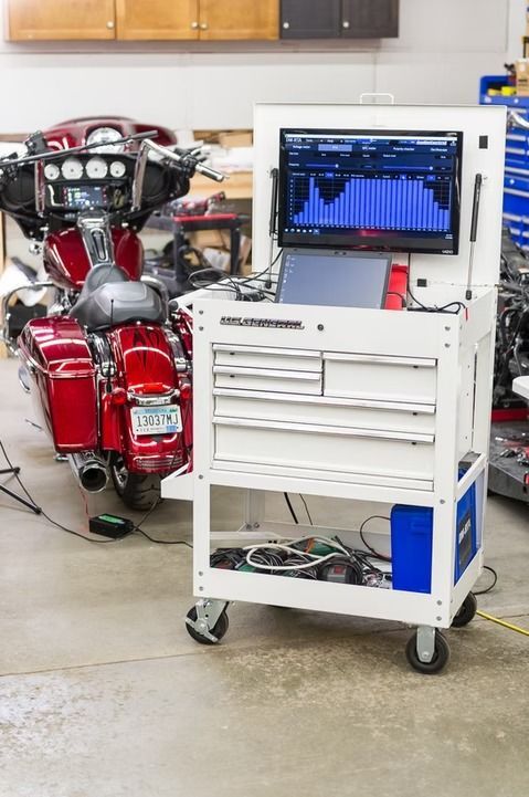 Red motorcycle with diagnostic equipment in a workshop garage