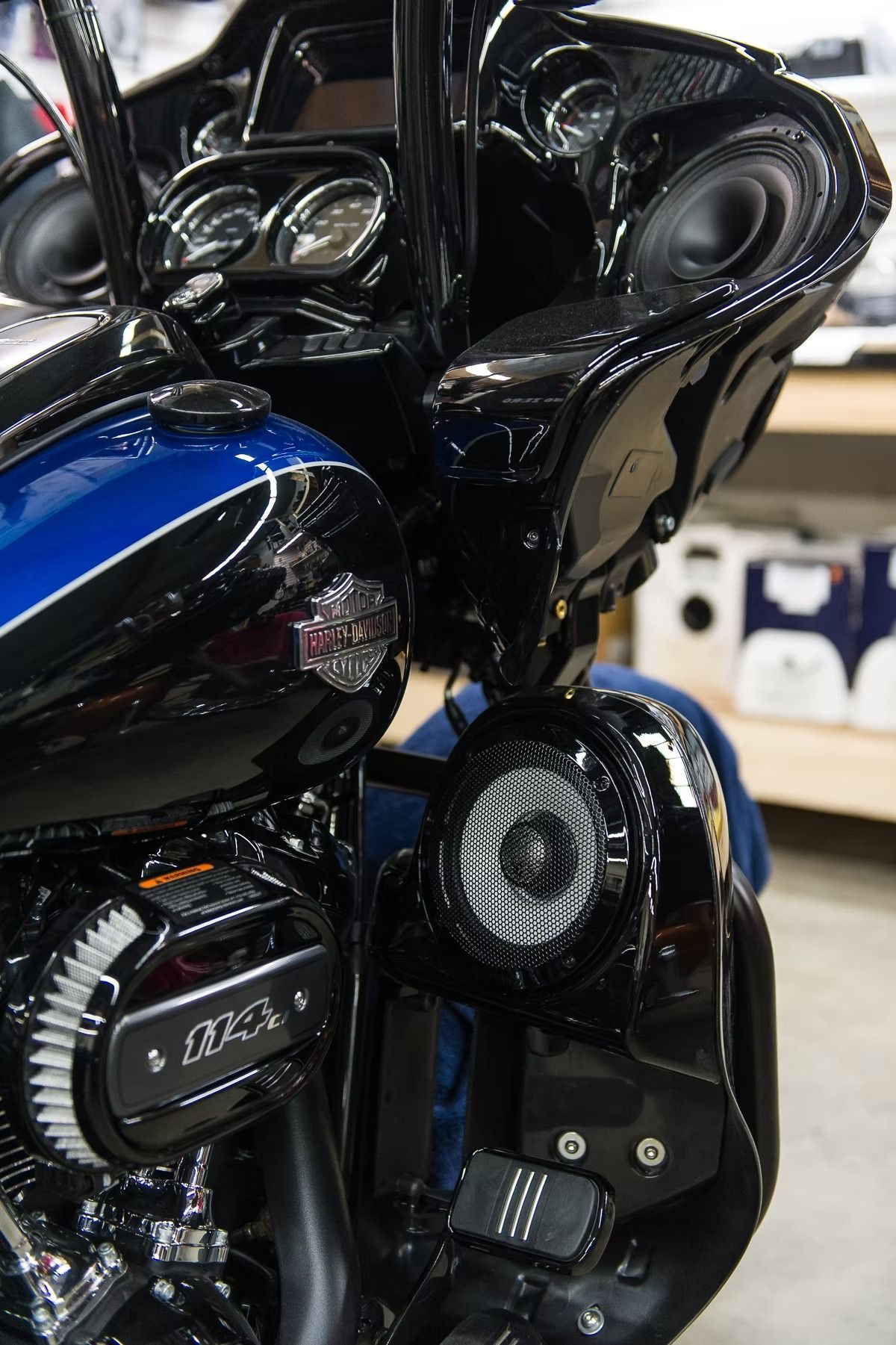 Close-up of a black and blue custom motorcycle with chrome detailing and speakers