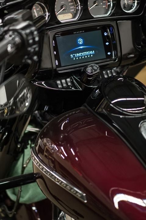 Close-up of a motorcycle dashboard and burgundy fuel tank with chrome trim