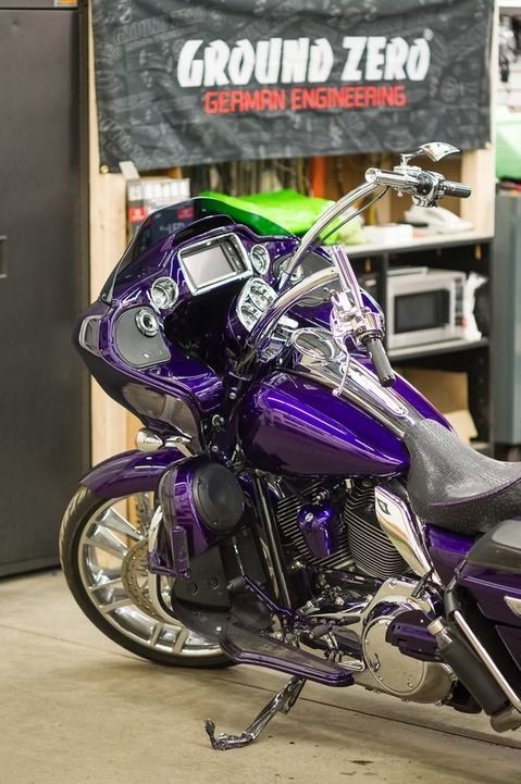 Purple custom motorcycle parked indoors beneath a Ground Zero sign