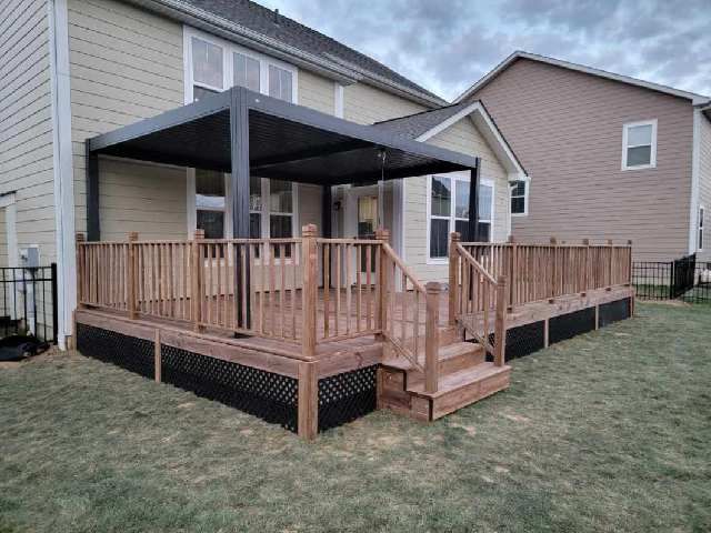 A wooden deck with stairs and a pergola in the backyard of a house.