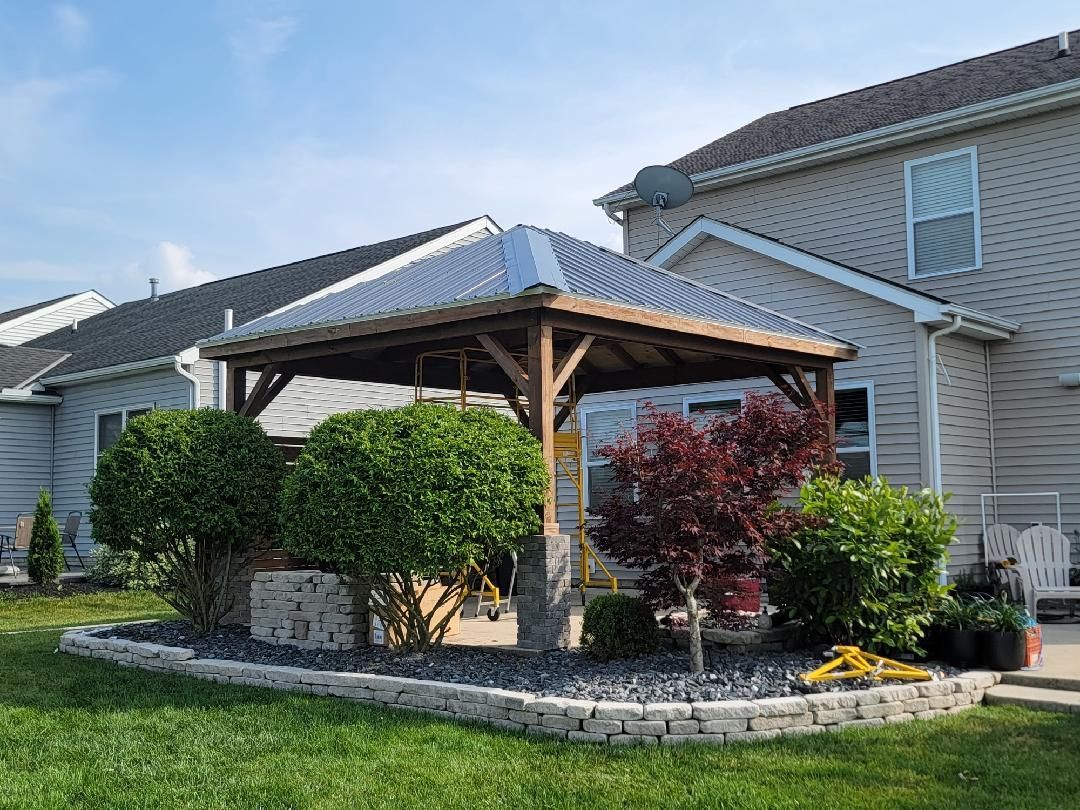 There is a gazebo in the backyard of a house.