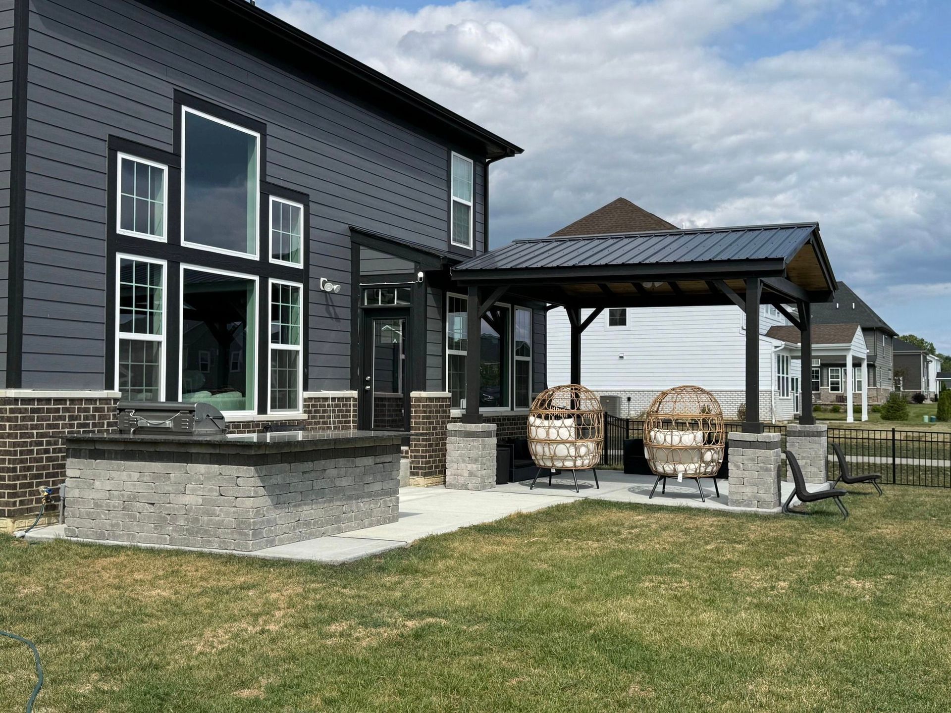 The backyard of a house with a patio area and a gazebo.