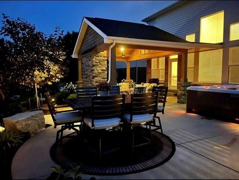 A patio with a table and chairs and a hot tub