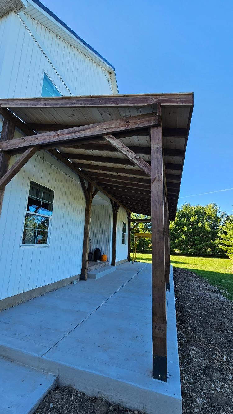 A white house with a wooden porch on the side of it.