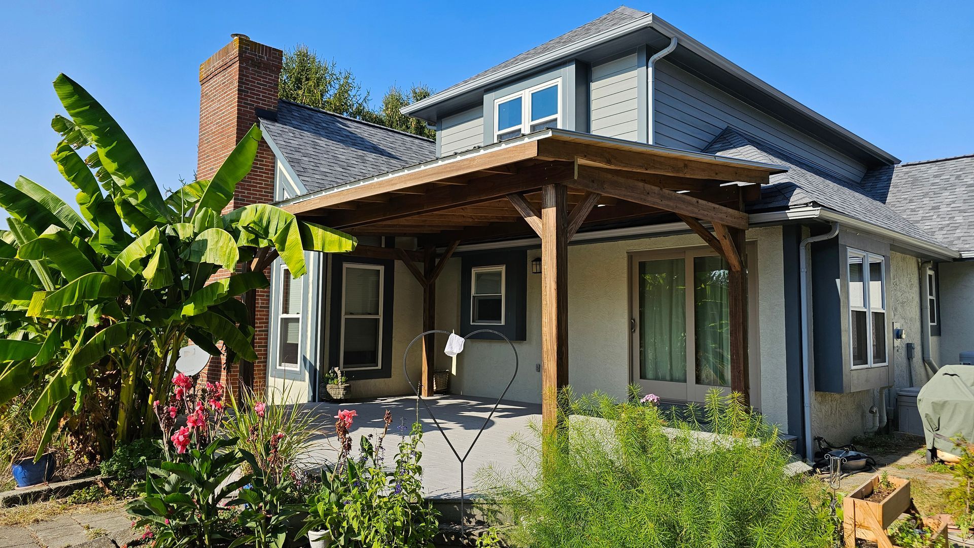 A house with a wooden pergola on the front porch.