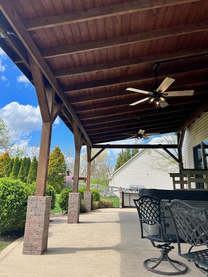 A covered porch with a ceiling fan and chairs.