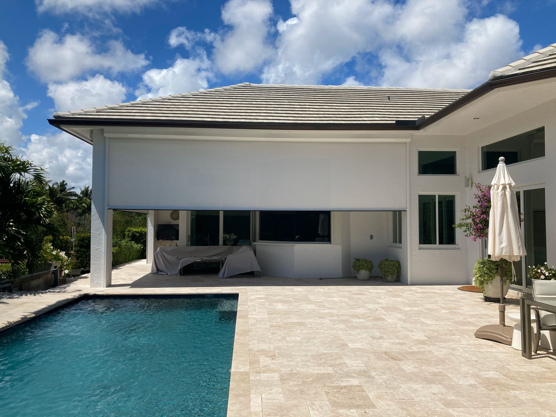 A large white house with a swimming pool in front of it.
