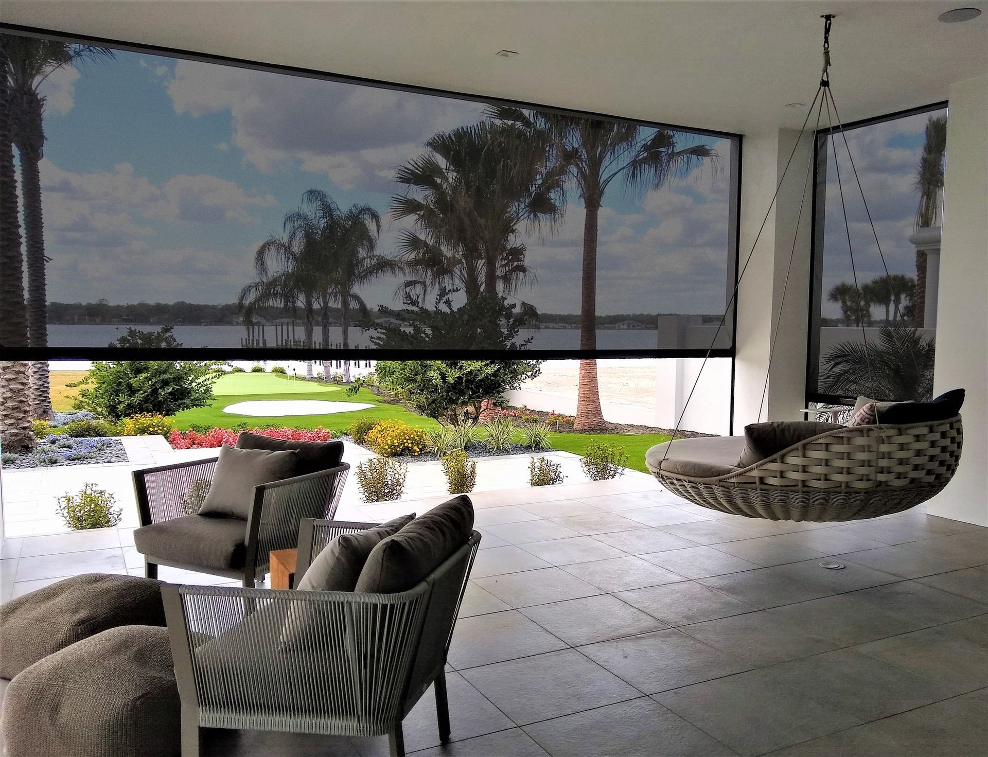 A patio with wicker chairs and a hanging chair