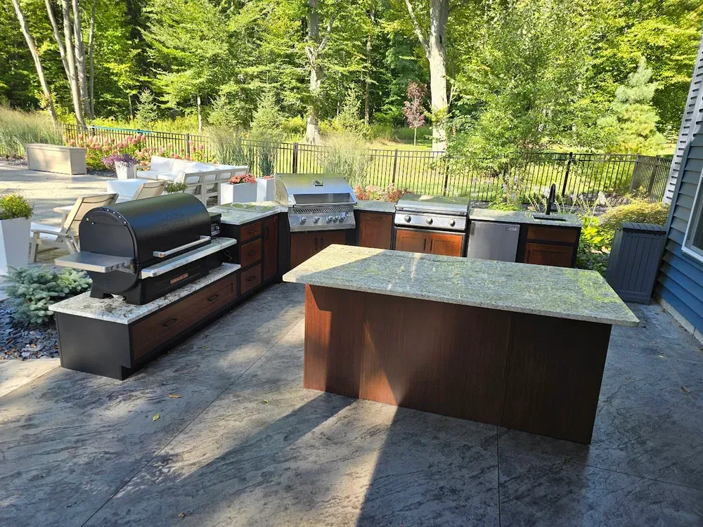 A large outdoor kitchen with a grill and a large island