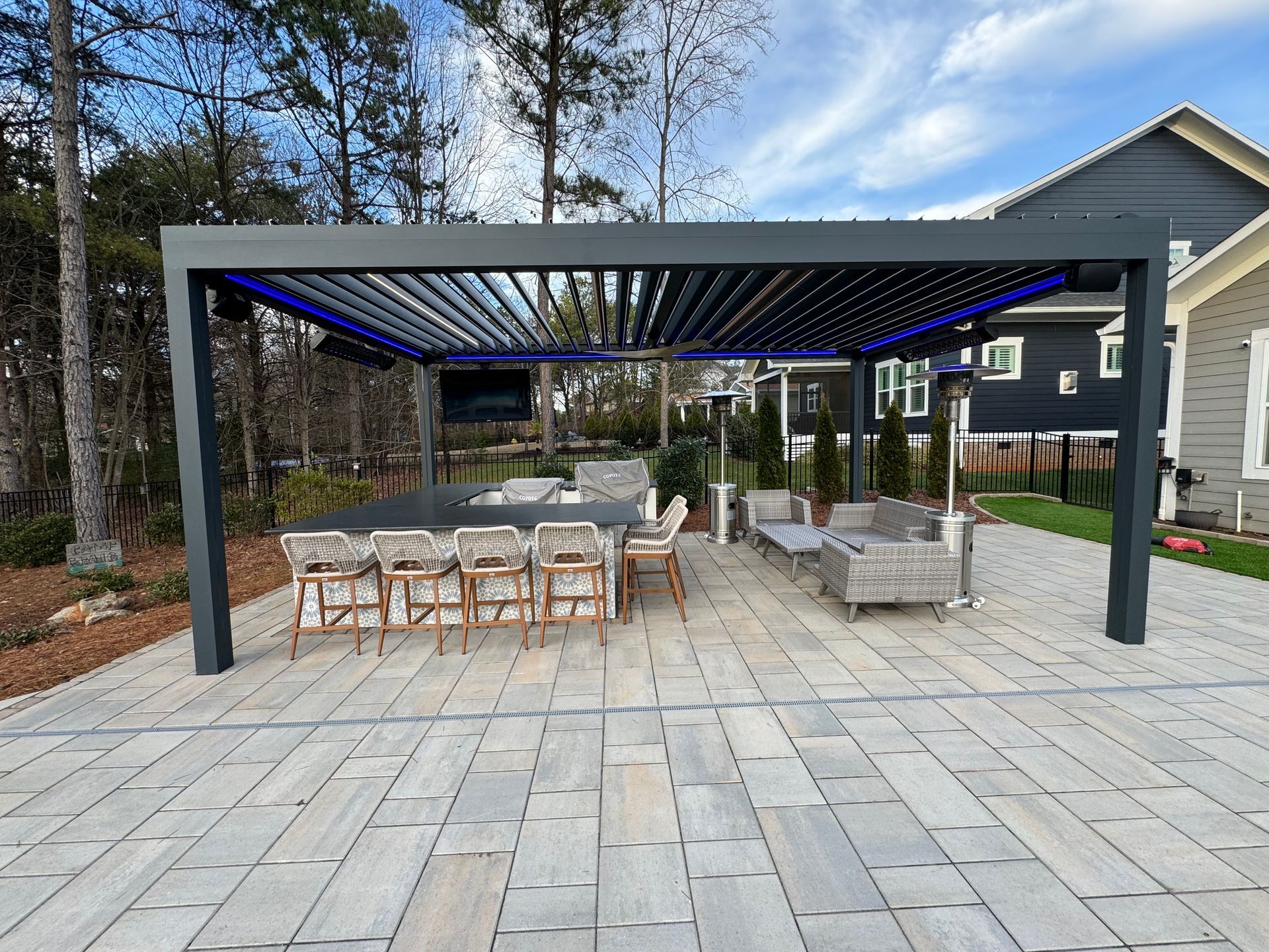 A patio with a table and chairs under a pergola.