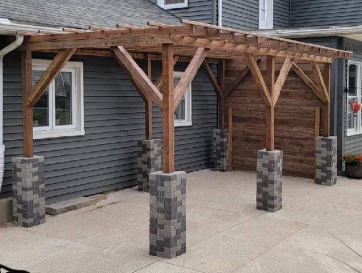 A wooden pergola is sitting in front of a house