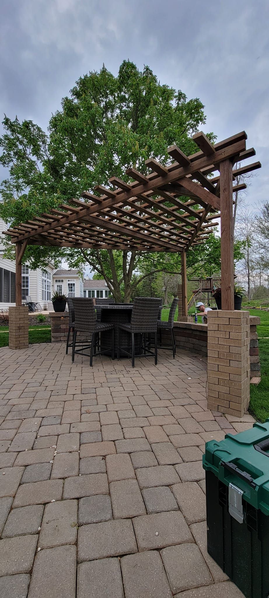 A patio with a pergola and a table and chairs underneath it.