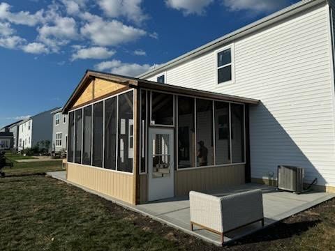 A screened in porch is being built on the side of a house.