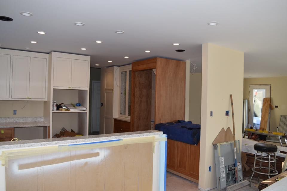 Kitchen under renovation, featuring cabinets, a partially built island, and recessed lighting.