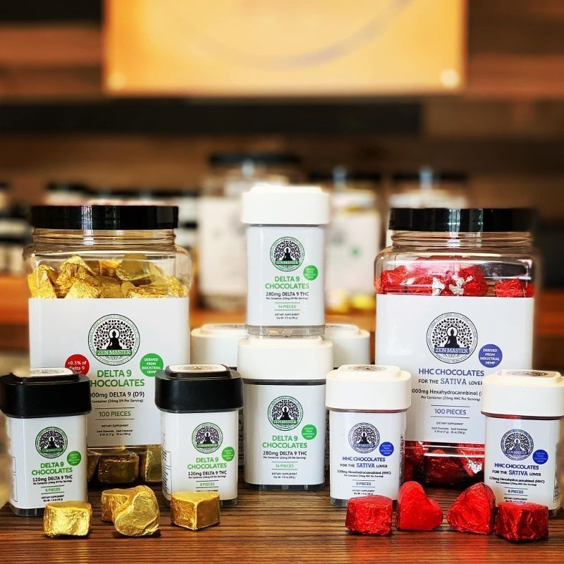 Assortment of chocolates in jars and containers, with white labels and green text; gold, white, and red wrapping