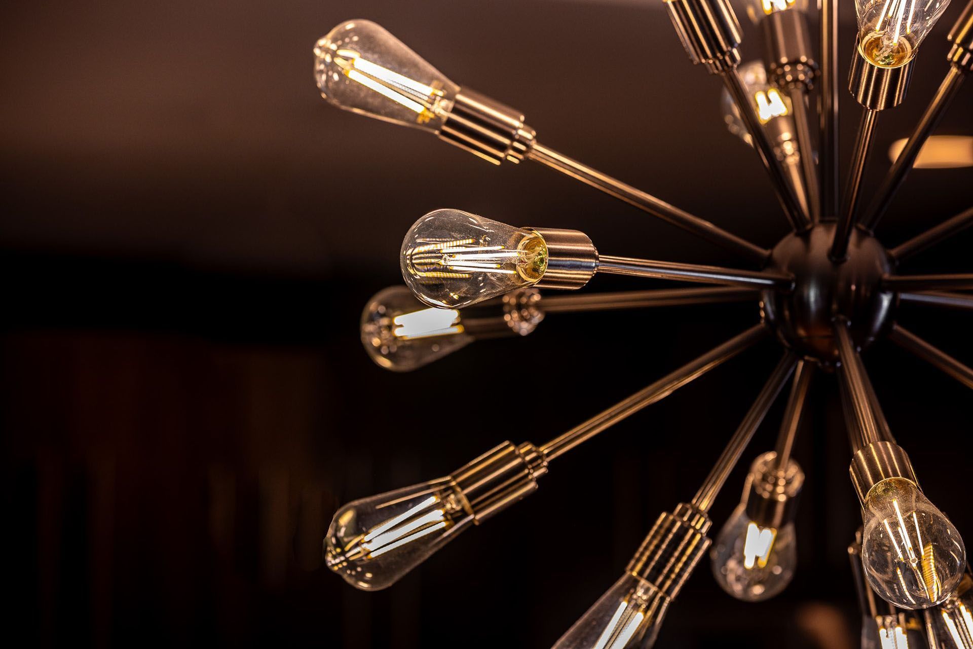 A close up of a chandelier with lots of light bulbs hanging from it.