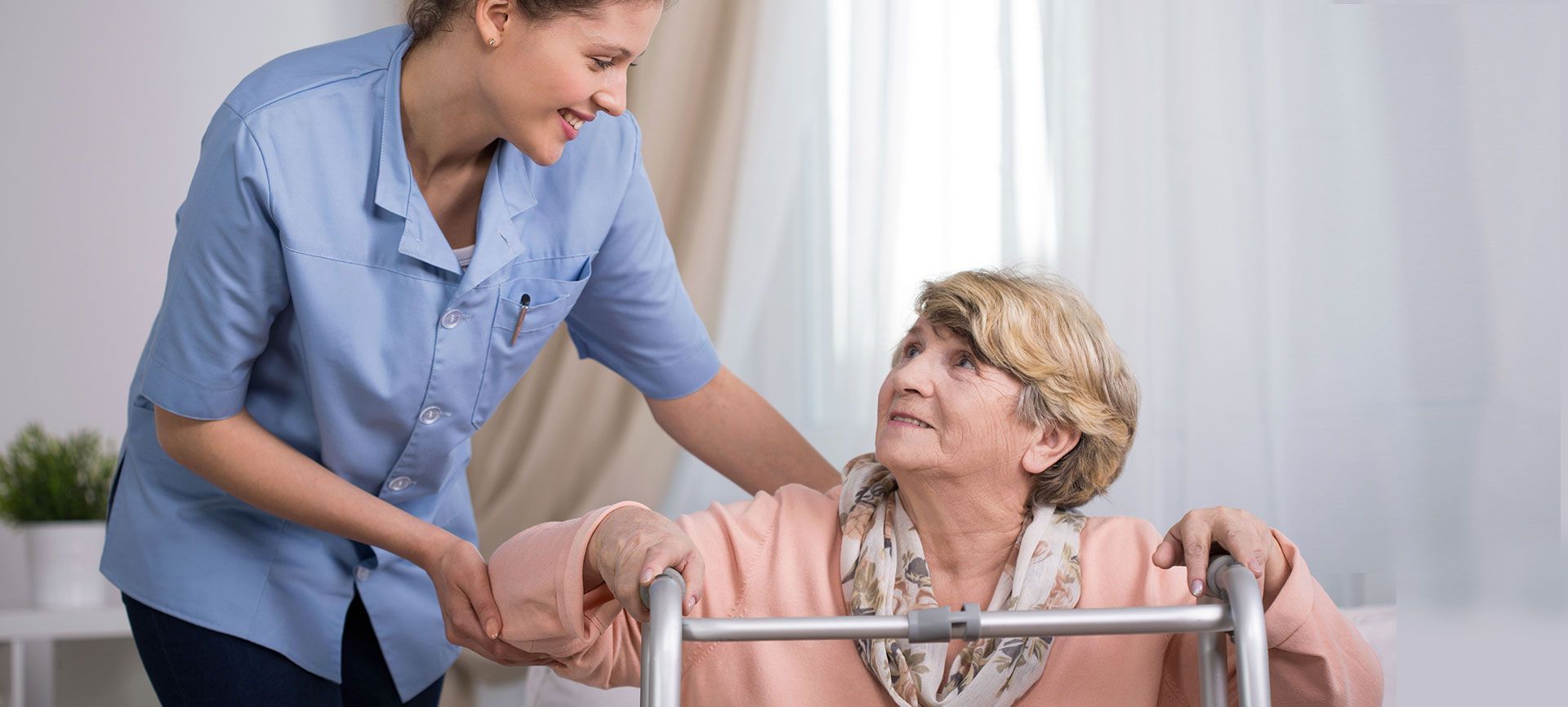A delivery driver smiles while unloading a cardboard box from a white van parked in front of suburban houses.