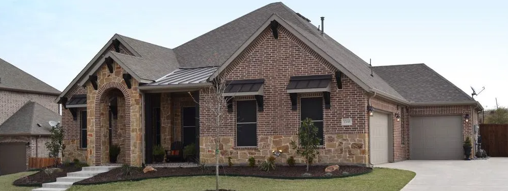 Brick home with stone accents, a two-car garage, and a gray roof on a sunny day.